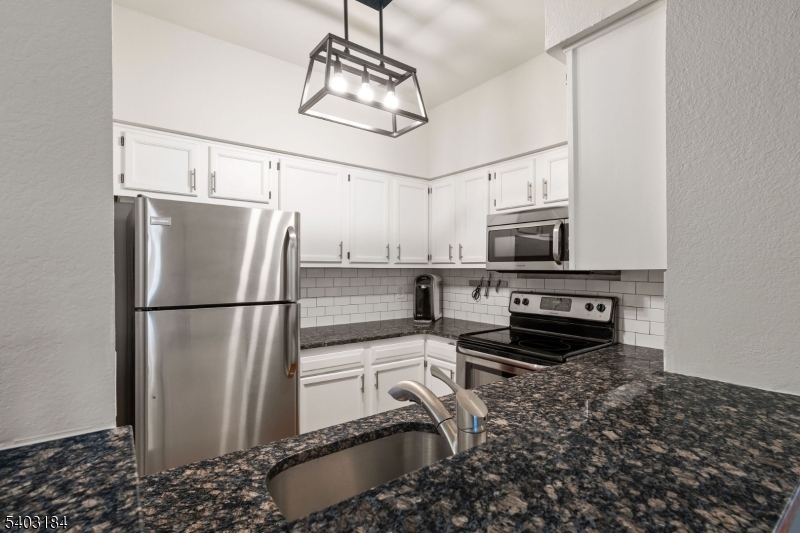 3 Wescott Road Bedminster, NJ 07921 - Photo 7 of 15 a kitchen with stainless steel appliances granite countertop a refrigerator a stove and a sink with wooden floor