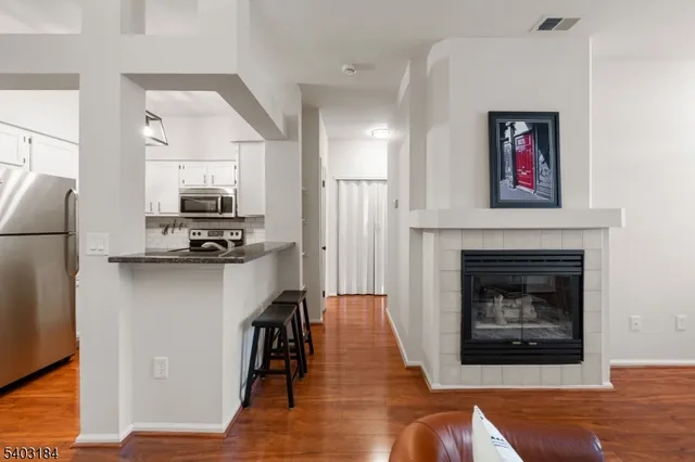 a living room with furniture a fireplace and kitchen view