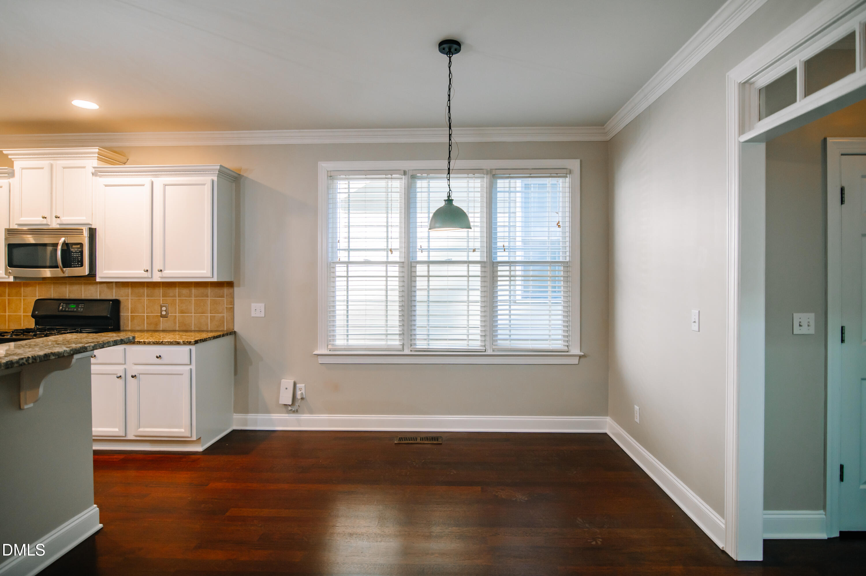 2106 Cloud Cover Lane Raleigh, NC 27614 - Photo 11 of 35 a kitchen with stainless steel appliances granite countertop a stove a sink and white cabinets with wooden floor next to windows