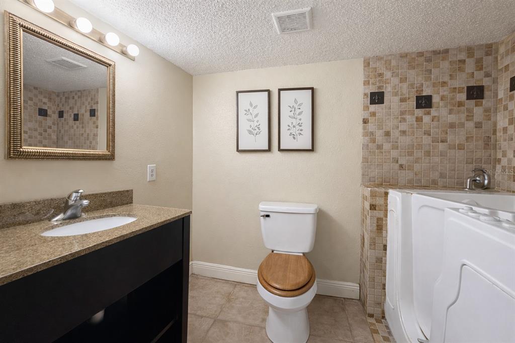 125 Water Front Way, Unit 110 Altamonte Springs, FL 32701 - Photo 12 of 17 a bathroom with a granite countertop toilet sink and mirror