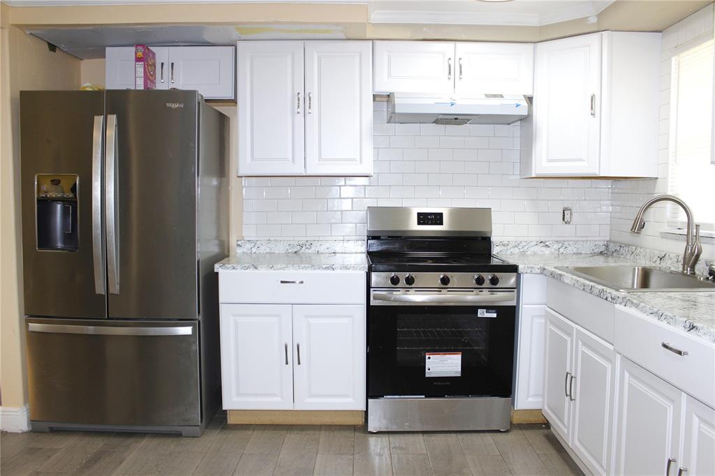 4550 Abdella Lane Holiday, FL 34690 - Photo 16 of 41 a kitchen with granite countertop a refrigerator stove and sink
