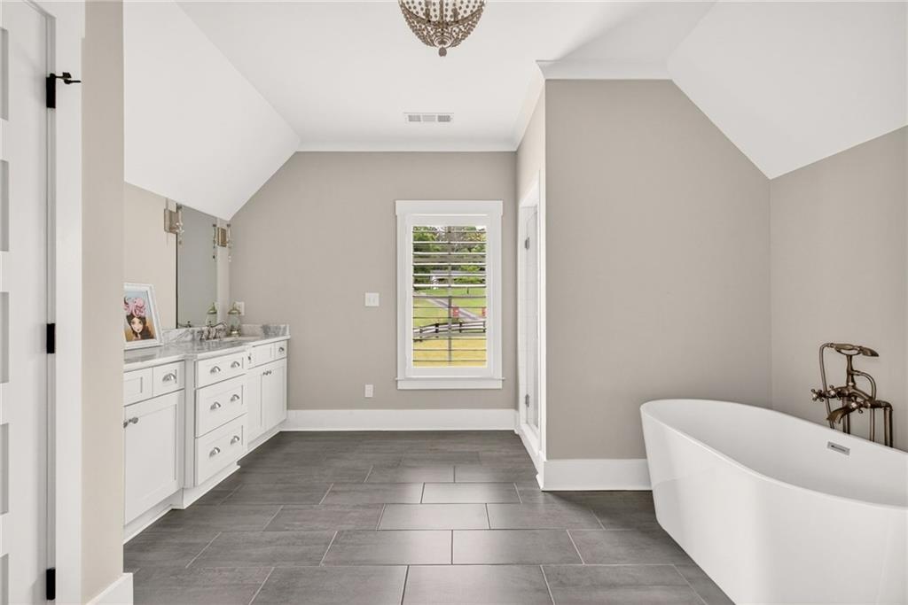 13460 New Providence Road Milton, GA 30004 - Photo 25 of 60 a bathroom with a bathtub sink and mirror