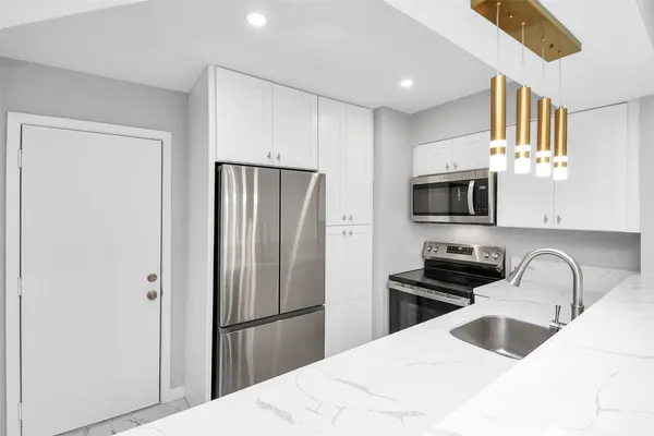 a kitchen with stainless steel appliances a refrigerator sink and microwave