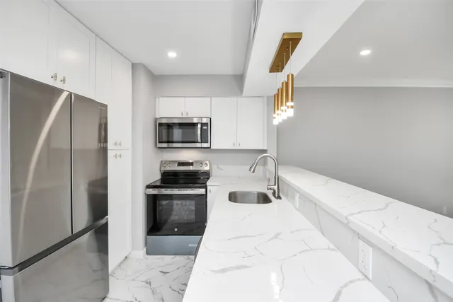 a kitchen with granite countertop a refrigerator and a sink