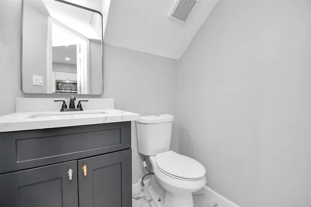 a bathroom with a sink a toilet and a mirror