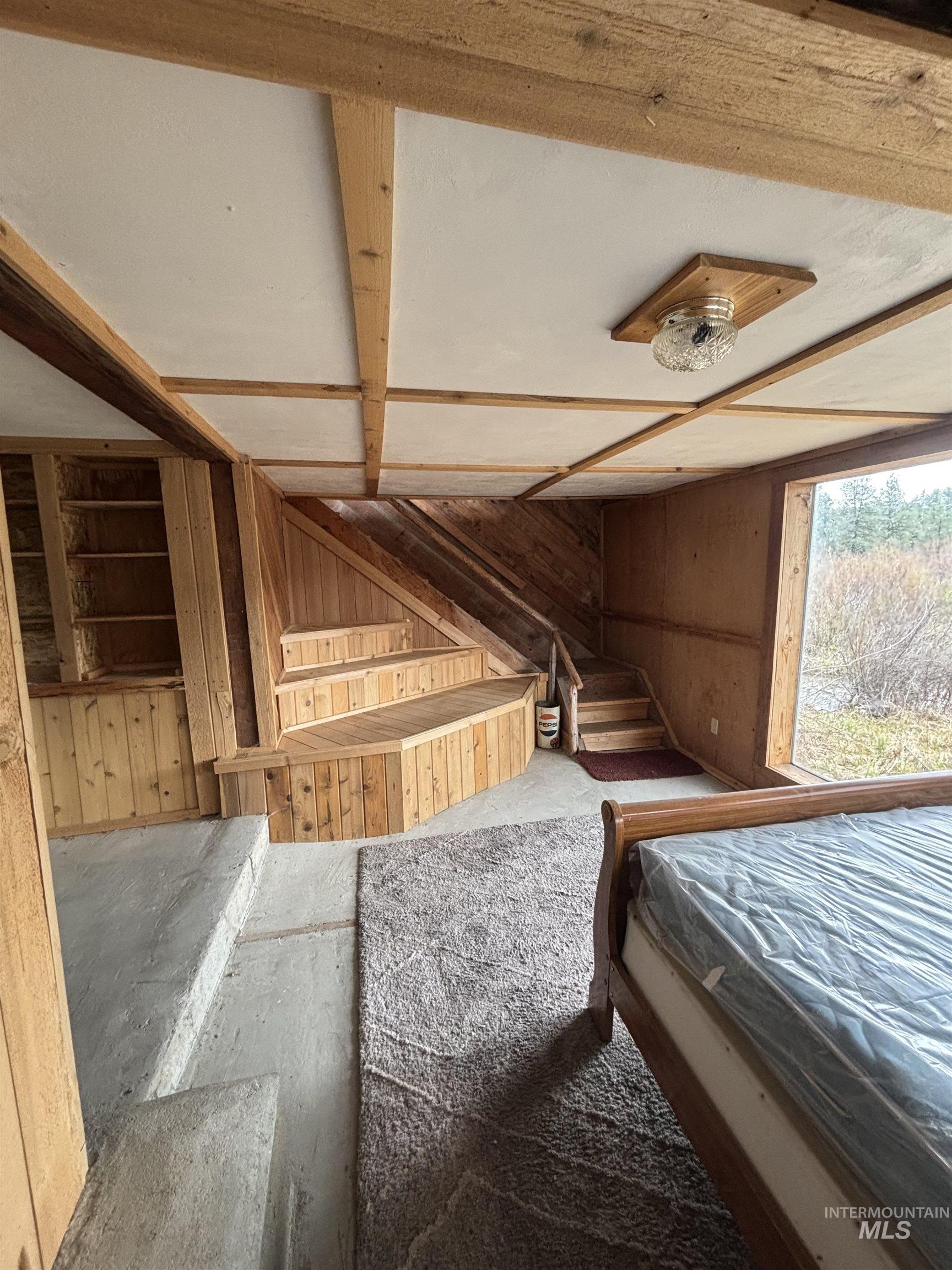 29 McIntyre Gulch Road Boise, ID 83716 - Photo 20 of 50 Wood-paneled interior featuring a built-in wooden staircase, exposed wood beam ceiling, and a flush-mount ceiling light
