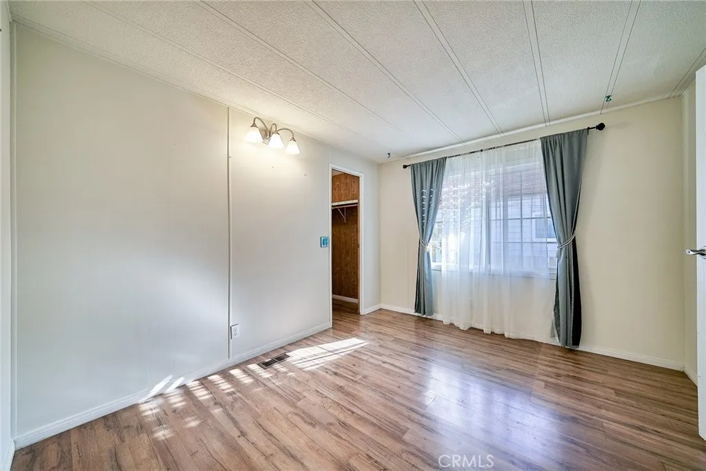 17701 Avalon, Unit 372 Carson, CA 90745 - Photo 24 of 32 an empty room with wooden floor and windows