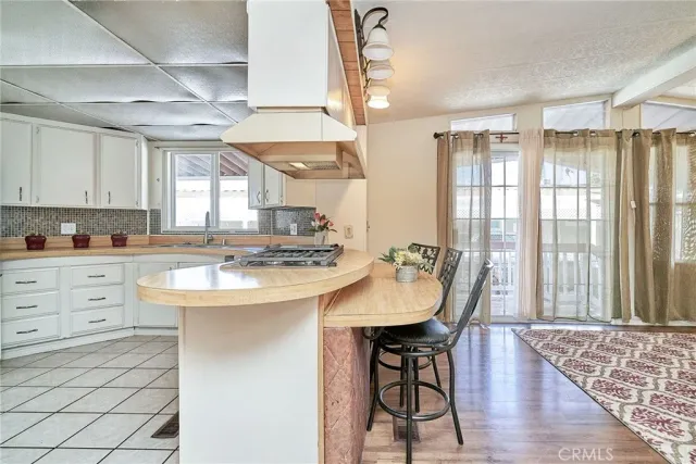 a kitchen with stainless steel appliances granite countertop a sink a stove a refrigerator and island with wooden floor