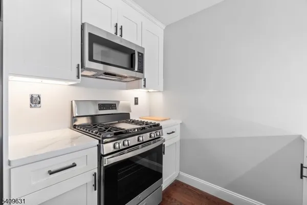 a kitchen with stainless steel appliances a stove a microwave and cabinets