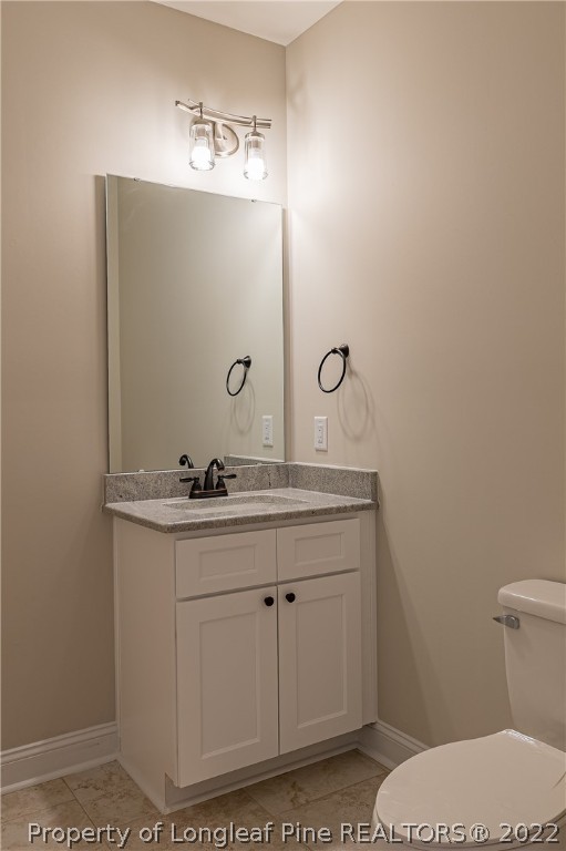 193 Kirk Road Aberdeen, NC 28315 - Photo 27 of 49 a bathroom with a granite countertop toilet a sink and mirror