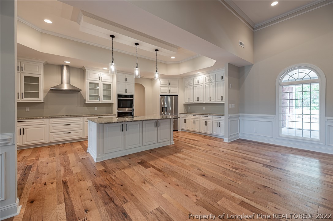 193 Kirk Road Aberdeen, NC 28315 - Photo 9 of 49 a large kitchen with stainless steel appliances kitchen island a large counter top and wooden floors