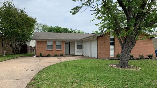 a front view of a house with a yard and trees