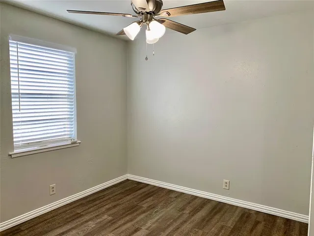 an empty room with a window and wooden floor