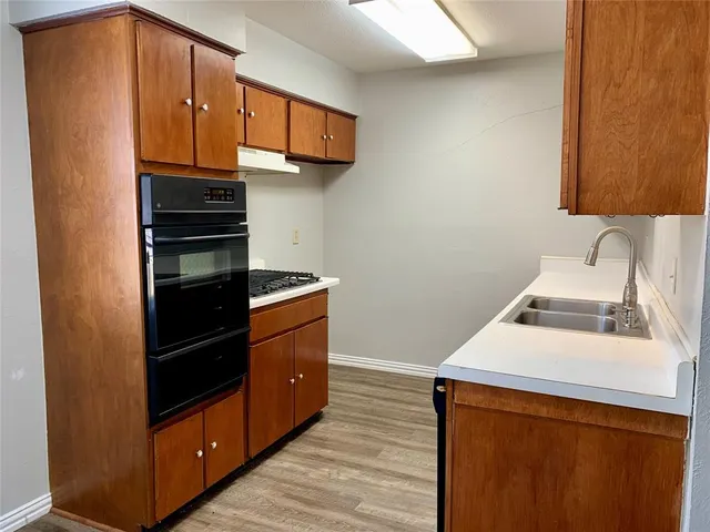a kitchen with wooden cabinets and a stove top oven
