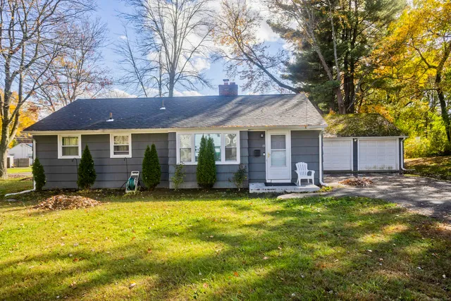 a front view of a house with a yard and trees