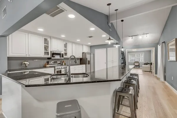 a kitchen with stainless steel appliances granite countertop a sink refrigerator and cabinets