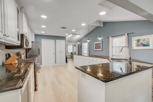 a large kitchen with stainless steel appliances granite countertop a large center island and a sink