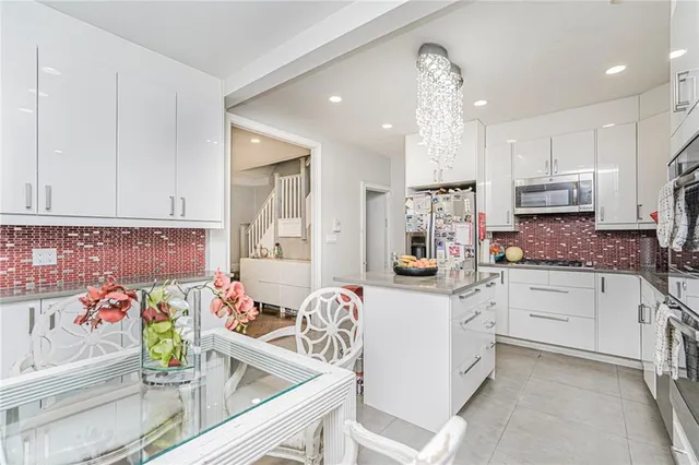 a kitchen with white cabinets and sink