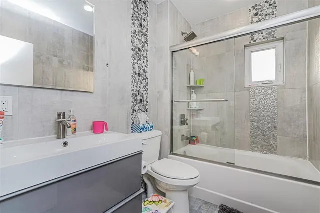 a bathroom with a sink toilet vanity and shower
