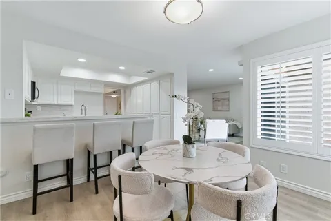 a kitchen with a dining table chairs and refrigerator