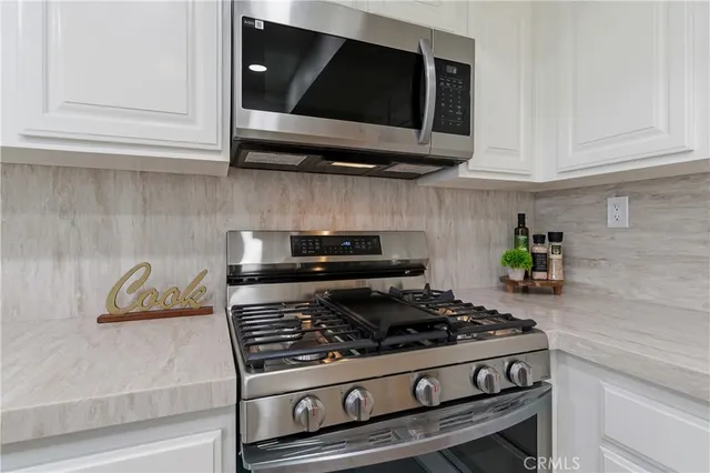 a stove top oven sitting inside of a kitchen