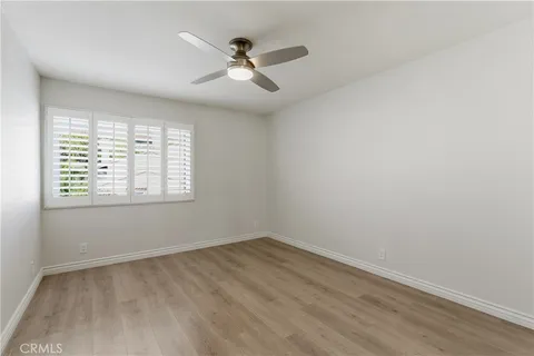 an empty room with a window and ceiling fan