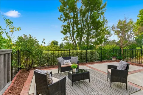 a view of a patio with couches table and chairs and potted plants