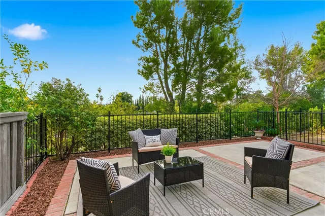 a view of a patio with couches table and chairs and potted plants