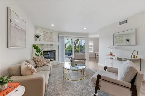 a living room with furniture fireplace and a large window