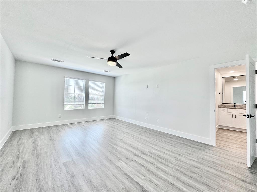 8509 Shorehan Road The Colony, TX 75056 - Photo 16 of 33 Empty room featuring light wood-style floors, a ceiling fan, and baseboards