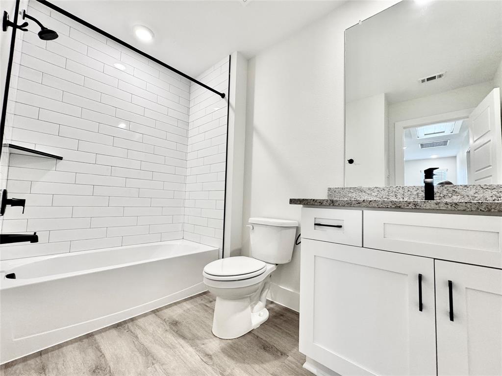 8509 Shorehan Road The Colony, TX 75056 - Photo 24 of 33 Full bathroom with wood finished floors, toilet, shower / washtub combination, vanity, and baseboards