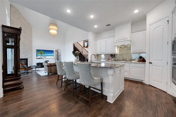 a kitchen with stainless steel appliances granite countertop a sink a stove a refrigerator and a microwave