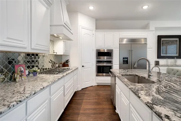 a kitchen with stainless steel appliances granite countertop a sink stove and cabinets