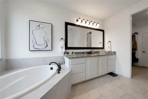 a bathroom with a bathtub sink and a mirror