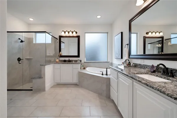 a spacious bathroom with a granite countertop sink mirror and bathtub