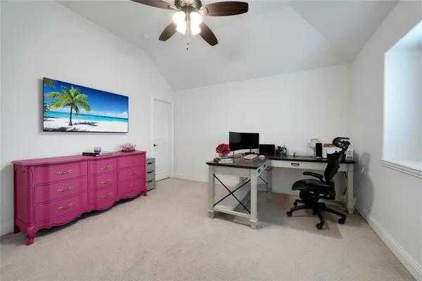 a view of a workspace with furniture and a window