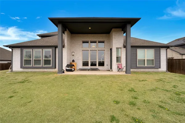 a view of a house with a yard and a large tree