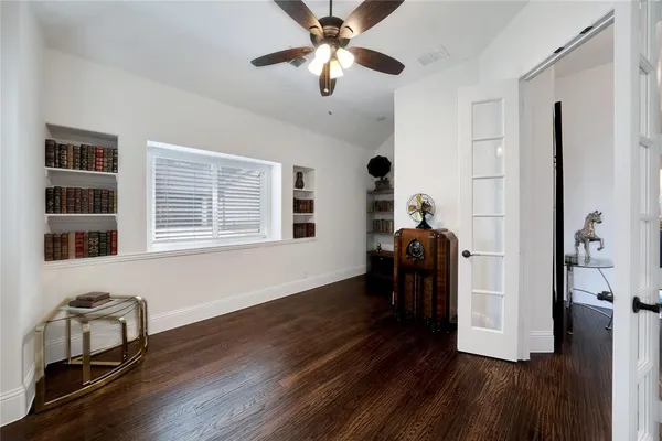 a view of a livingroom with wooden floor and a ceiling fan