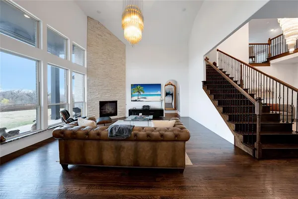 a room with wooden floor pool table and chairs