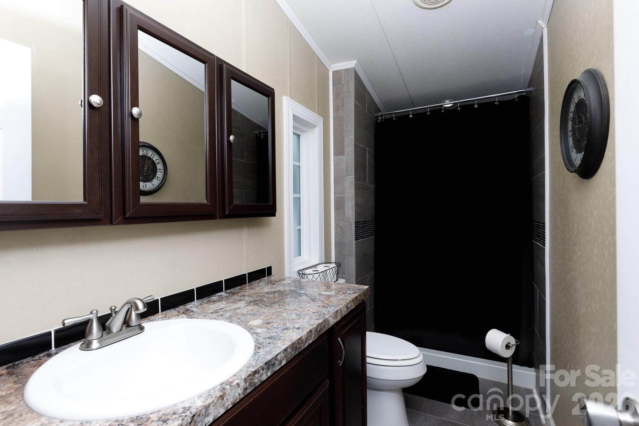 652 Sutton Spring Road York, SC 29745 - Photo 13 of 28 a bathroom with a granite countertop sink and a mirror