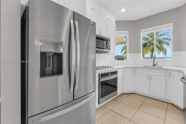 a kitchen with stainless steel appliances a refrigerator sink and microwave