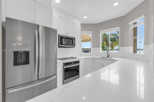 a large kitchen with a large window and stainless steel appliances