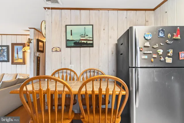 a kitchen with stainless steel appliances granite countertop a refrigerator and a dining table