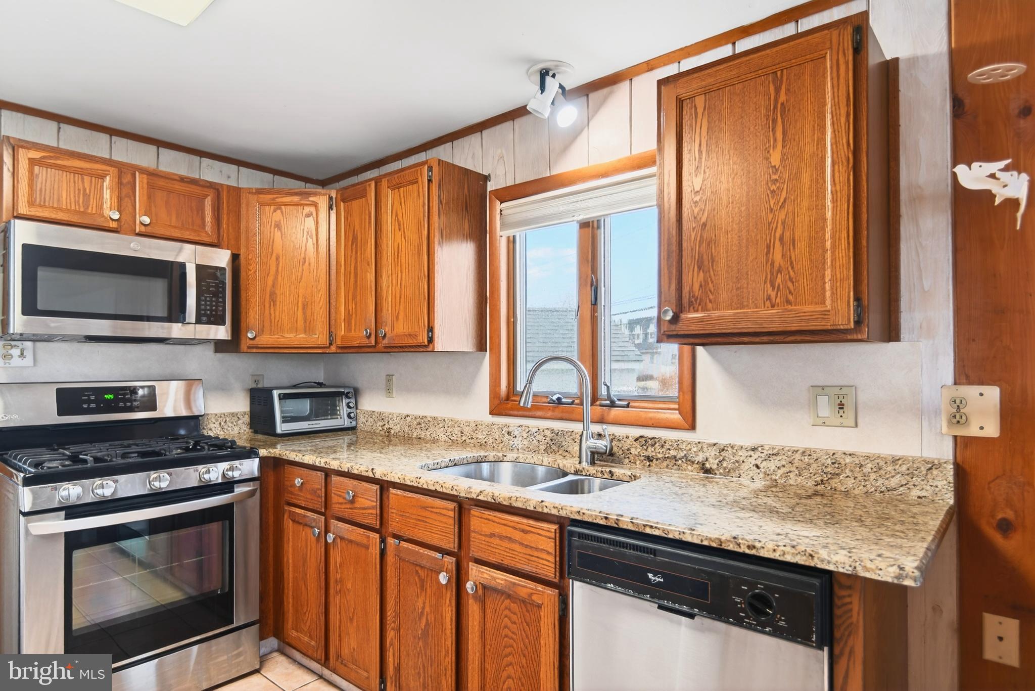4 Rona Lane Manahawkin, NJ 08050 - Photo 10 of 28 a kitchen with granite countertop a sink stainless steel appliances and cabinets