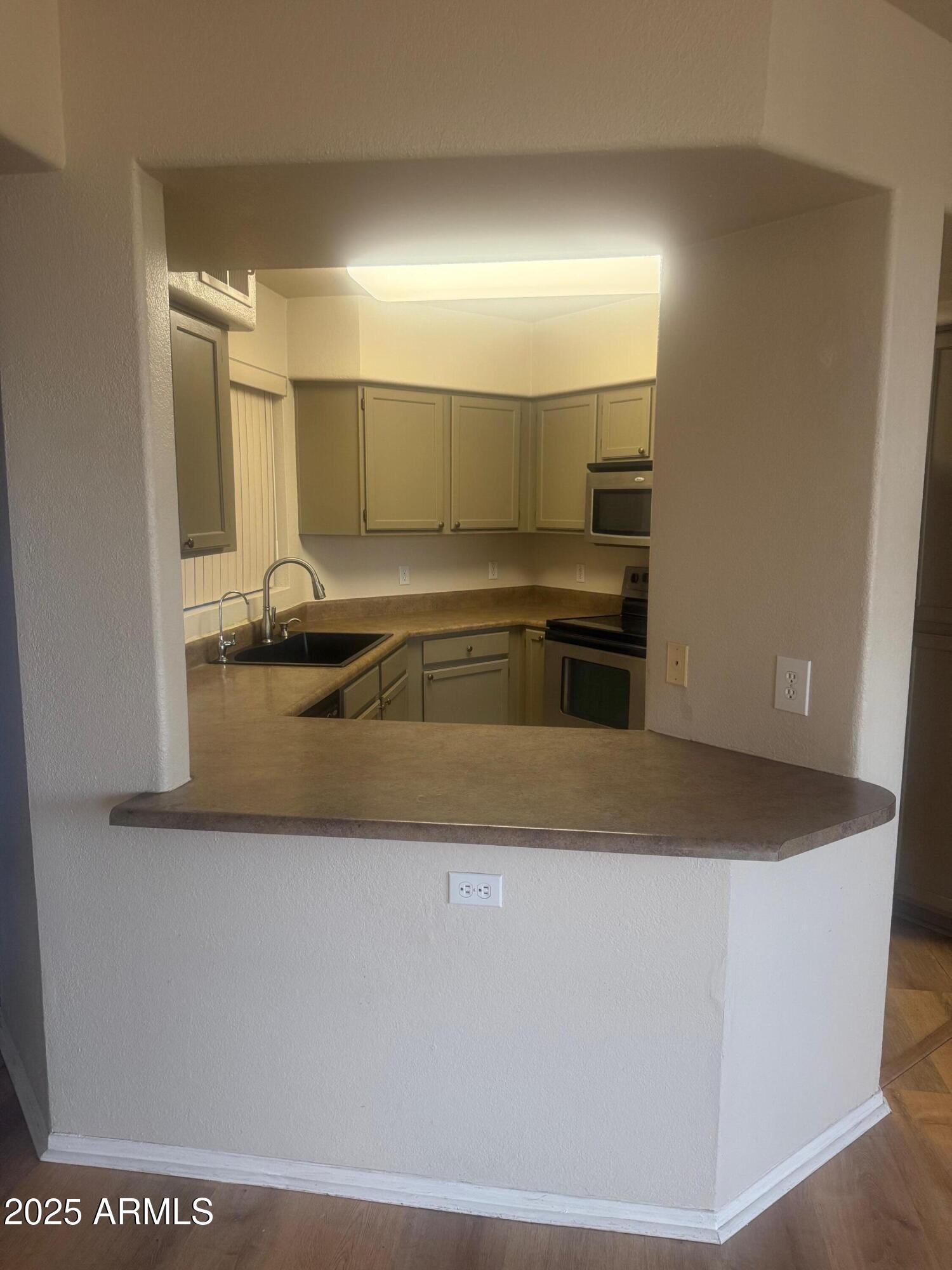 3848 North 3rd Avenue, Unit 2071 Phoenix, AZ 85013 - Photo 14 of 31 a kitchen with kitchen island a sink a stove and a refrigerator