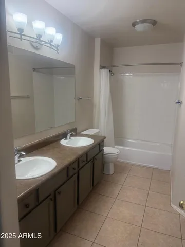 a bathroom with a double vanity sink toilet and a mirror