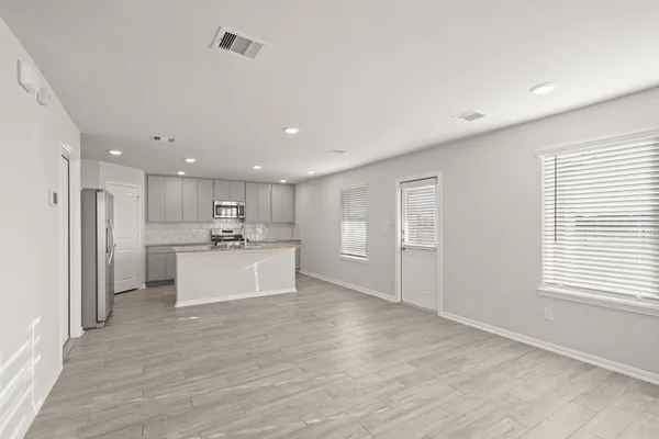 a view of kitchen with kitchen island white cabinets wooden floor and center island