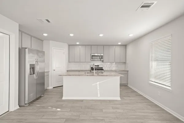 a large kitchen with stainless steel appliances kitchen island a refrigerator sink and cabinets