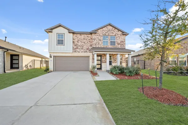 a front view of a house with a yard and garage