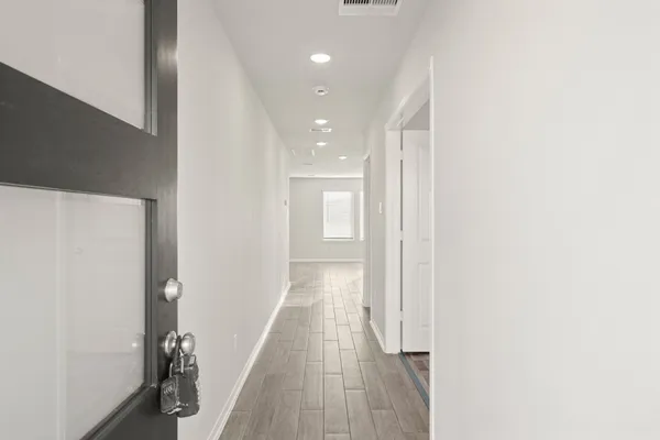 a view of a hallway with wooden floor
